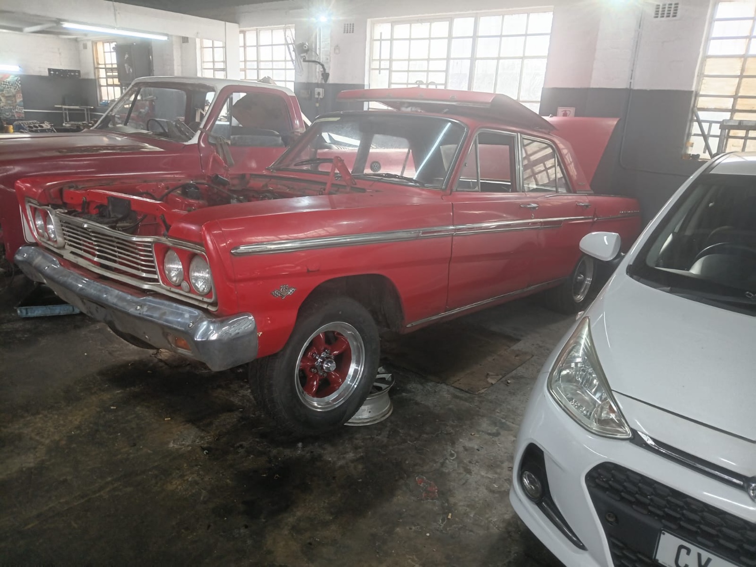 Fairlane in the workshop with the bonnet and engine removed.
